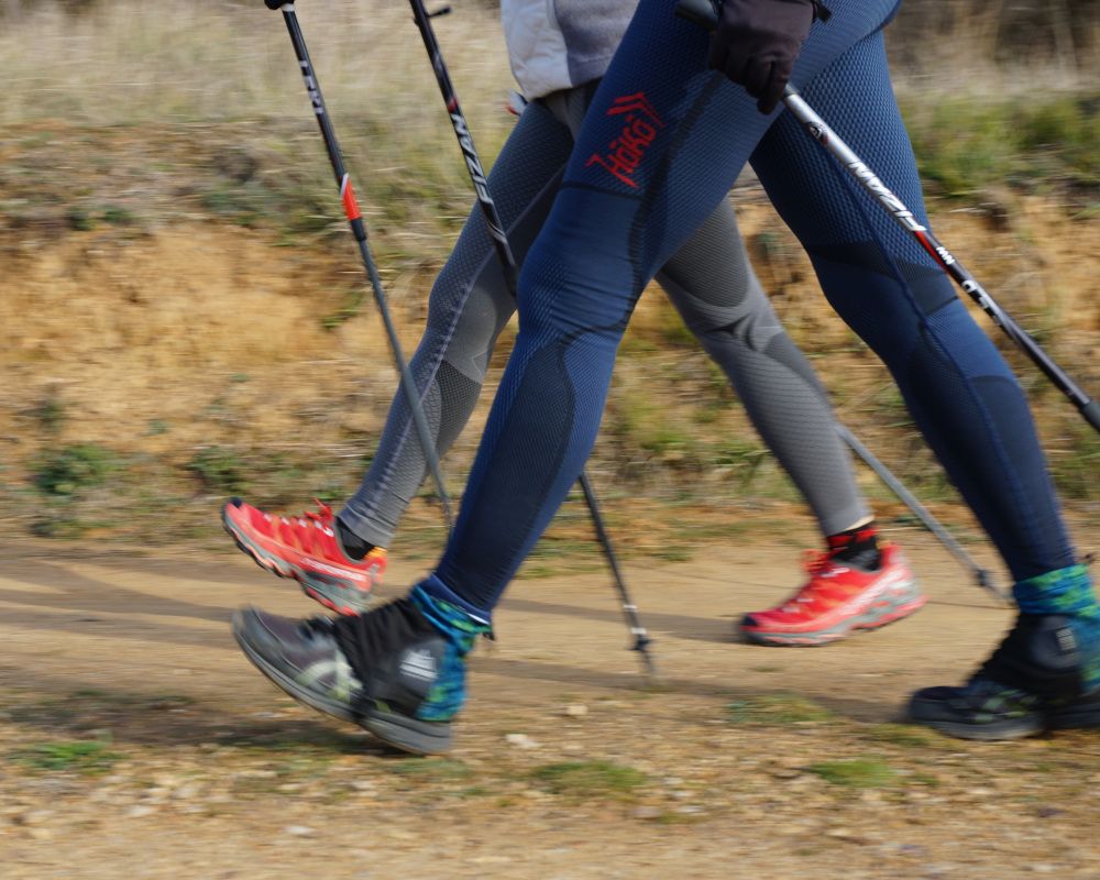 Primer plano de unas piernas practicando Nordic Walking.